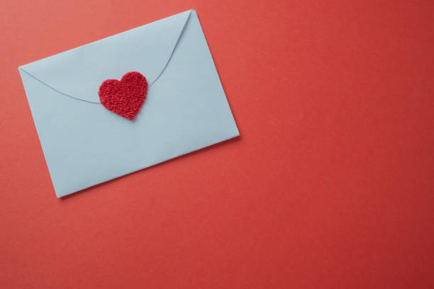 istock White card with a heart closeup on a red background with copy space. 1935016262