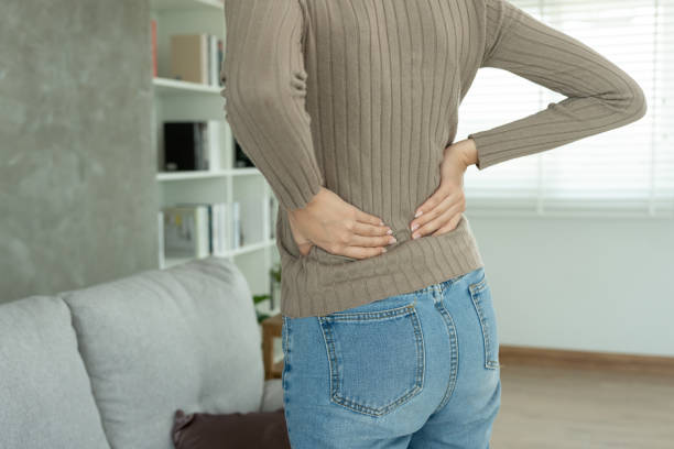 istock woman holding her lower back while and suffer from unbearable pain health and problems, chronic back pain, backache in office syndrome, scoliosis, herniated disc, muscle inflammation 1935026299