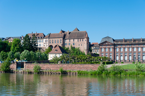 Saverne, France - May 26, 2022: View over Rhine-Marne Canal to Old Episcopal Castle in Saverne. Department of Bas-Rhin in Alsace region of France