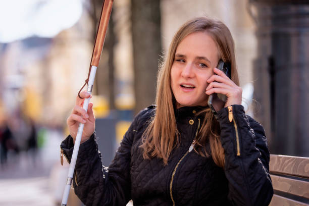 istock A visually impaired woman holding a white cane and having a call outside 1935040109