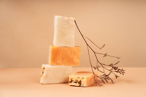istock Patterns of natural handmade soap in different sizes and colors. Peach background natural materials, wood, dried flowers. Cosmetic pedestal for product promotion. 1935055225