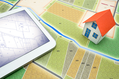 Buildings Permit concept with rural cadastral map and General Urban Plan - building activity and construction industry concept with a digital tablet and home model