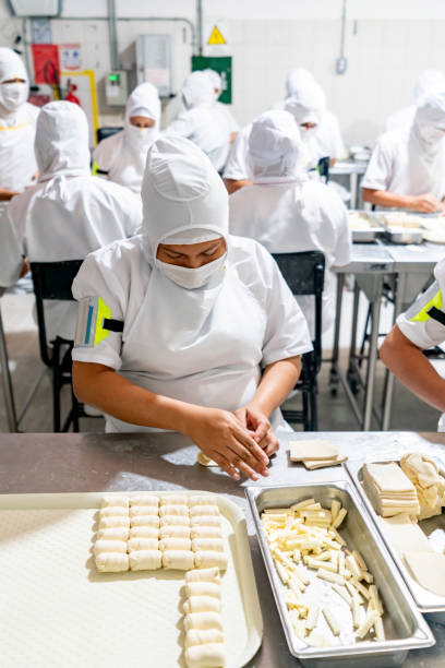 istock Woman working at an industrial bakery rolling pastries 1935070351