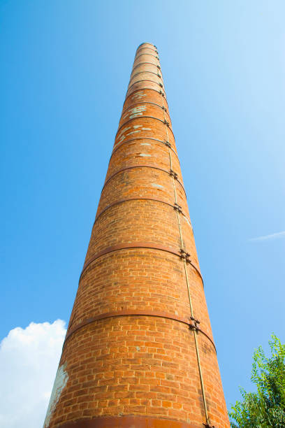 istock Old brick chimney isolated on sky with metal reinforcements 1935100006