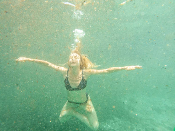 istock Woman floating underwater, letting go 1935107546