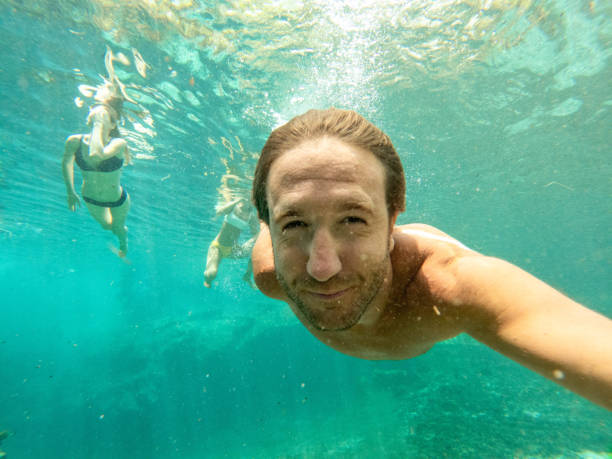 istock Man takes selfie underwater with friends 1935108061
