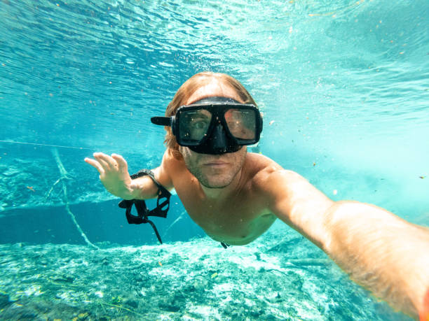 istock Man takes selfie underwater while swimming in a clear clean water 1935111415