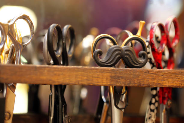 Mustache shaped hair clip on a barber scissors stand and empty space for text