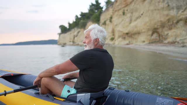 Senior man kayaking at sunset
