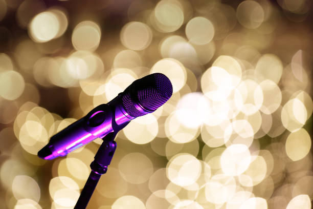 istock Microphone on stage in front of blurred lights and empty space for text 1935119539