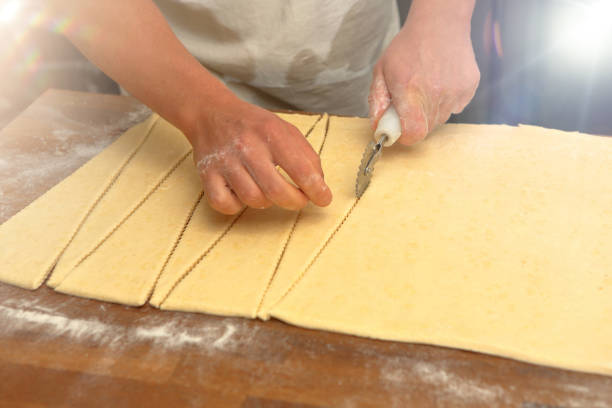 istock Baker cuts the dough for croissants and empty space for text 1935125287