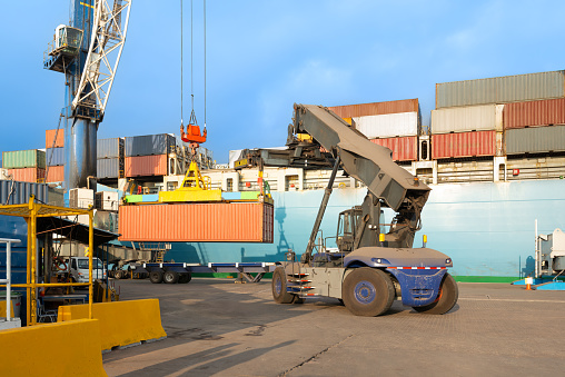 Containers being unloaded from a cargo ship at a port in Chile.