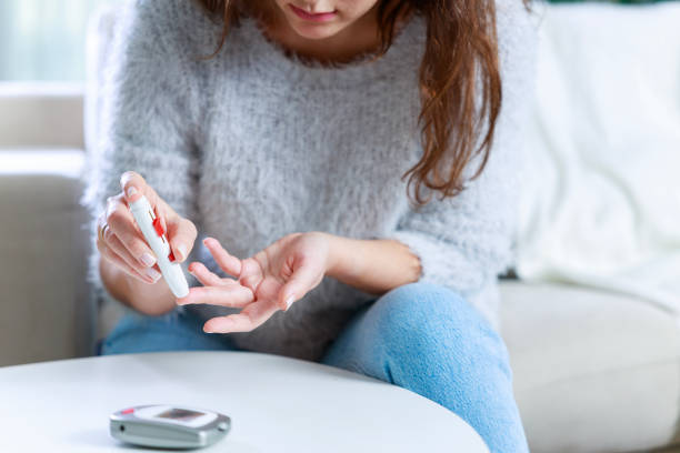 istock Young woman doing blood sugar test at home 1935129684