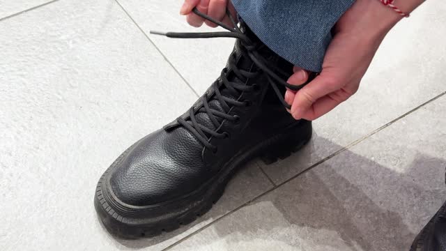 Trying new black boot in shoe store