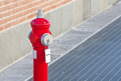 Metal red paint fire hydrant in a urban area - image with copy space