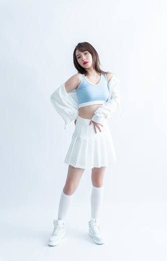 Young Asian woman in a white pleated skirt and blue sports bra