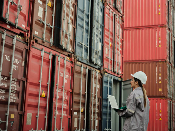 istock Female worker wearing safety helmet and working with container 1935143794