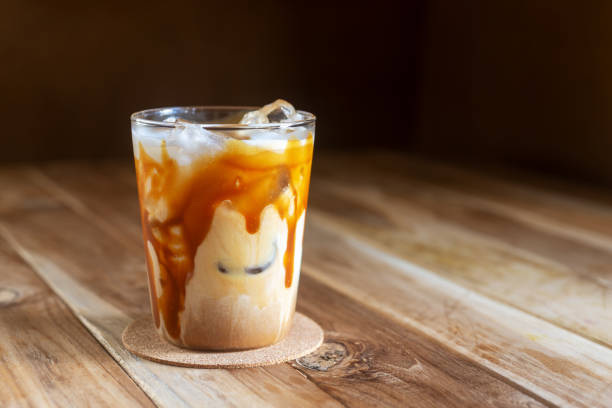 ice caramel macchiato coffee on  wooden table. a glass of ice caramel macchiato coffee on  wooden table, summer beverages. macchiato stock pictures, royalty-free photos & images