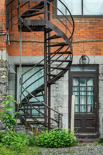 Rusty metallic outside spiral stairs on a brick building in Montreal, Canada