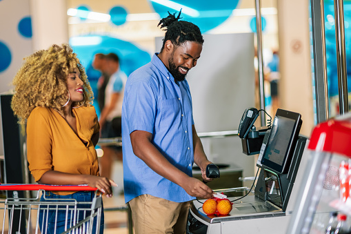 African American couple buying food at grocery store or supermarket self-checkout