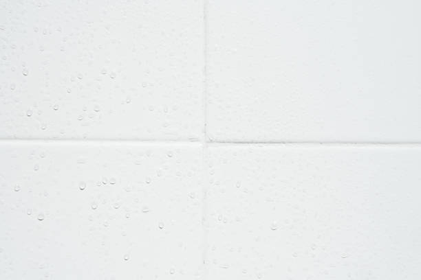 istock drop of water on white tiles wall texture background. 1935178594