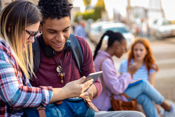 istock Diverse group of students sitting on stairs takling and learning together. 1935179120