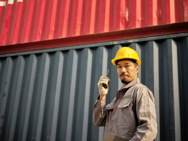 istock Asian worker wearing safety helmet and using walkie talkie 1935180272