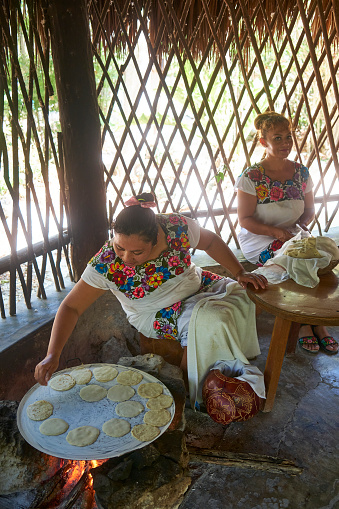 Two native Mayan women prepare tortillas in the traditional way in the Mayan village of Dos Palmas, in the Mexican state of Quintana Roo.