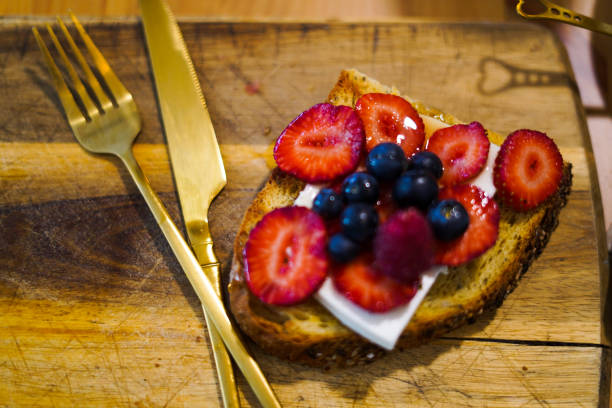 Blueberry and strawberry toast with golden cutlery