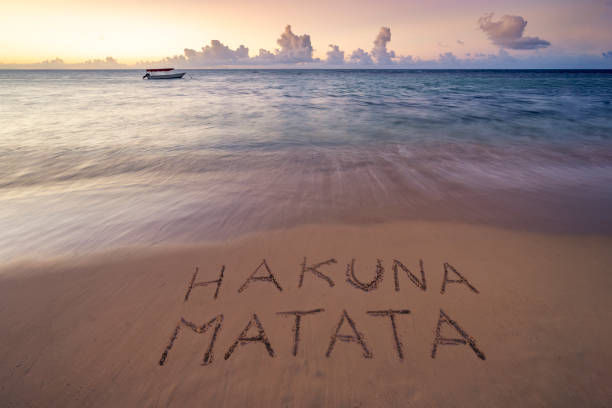istock Handwritten Hakuna Matata on sandy beach at sunset african beach 1935197340