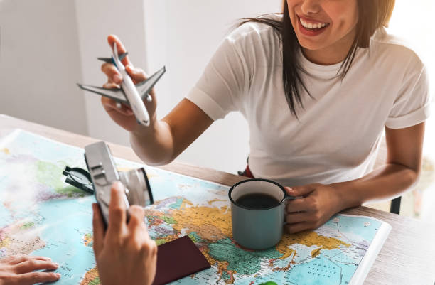istock Happy couple planning next travel destination using world map - Young playful people having fun and getting ready for vacation - Relationship and Traveling lifestyle concept 1935203707