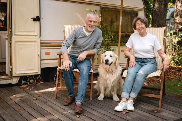 époux européens mari et femme se détendant sur les chaises de plage avec chien golden retriever - motor home mobile home camping senior adult photos et images de collection