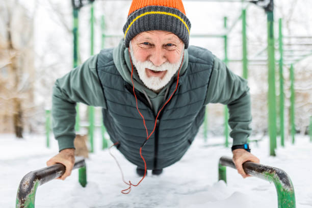 istock Senior man doing push-ups in the park during winter 1935228987