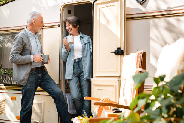 couple actif prenant le petit déjeuner sur le porche d’un camping-car remorque - motor home mobile home camping senior adult photos et images de collection