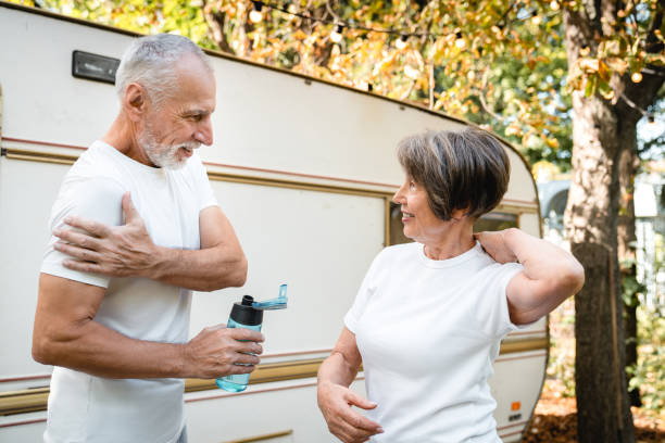 des grands-parents caucasiens s’entraînent ensemble en faisant du fitness tout en voyageant en roulotte - motor home mobile home camping senior adult photos et images de collection