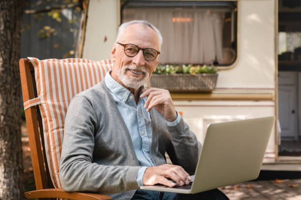 istock Busy old elderly senior grandfather using laptop for remote work freelance 1935263308