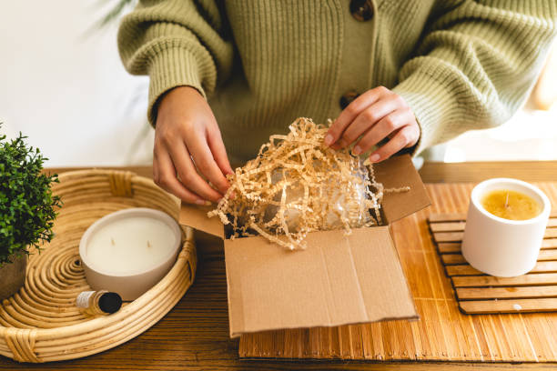 istock Young woman wraps the scented candle she made as a gift 1935308753