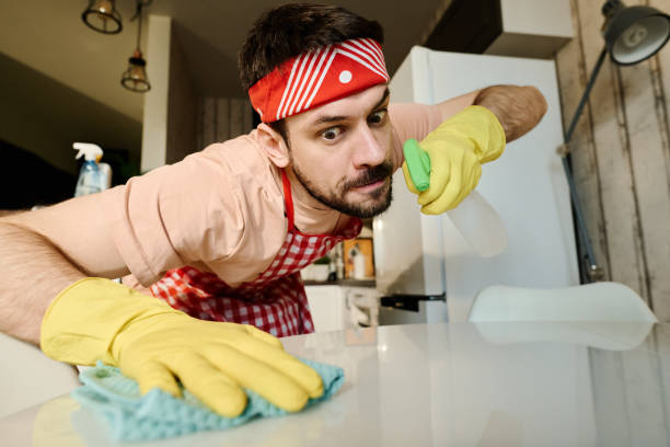 istock Man in gloves wiping table with duster 1935317208