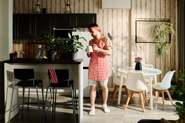 istock Young man watering green plants at home 1935317226