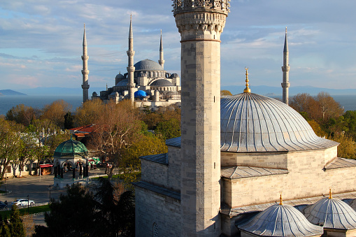 Panoramic view of the historic part of Sultanahmet district with mosque, square and fountain with Bosphorus Strait in the background against a blue sky with clouds in Istanbul