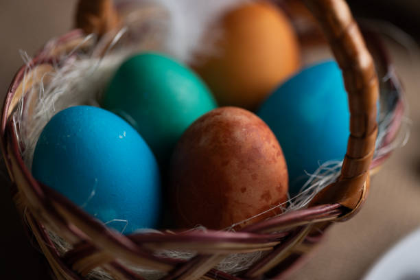 Close-up of multi coloured Easter eggs in wicker basket. Homemade colouring with onion peel and food coloring