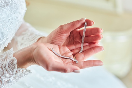 A beautiful piece of jewelry in women's hands. Packing and preparation for the wedding.