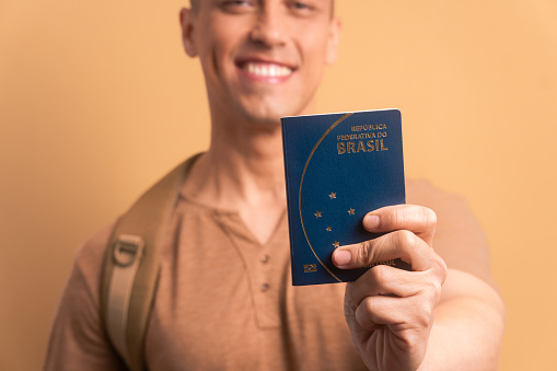 hands of man showing brazilian passport