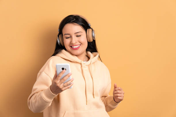 cheerful woman listening to music with headphones - neutral look audio - fotografias e filmes do acervo