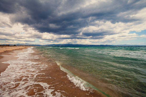Seascape with the dramatic cloudy stormy sky. Deserted beach in windy weather