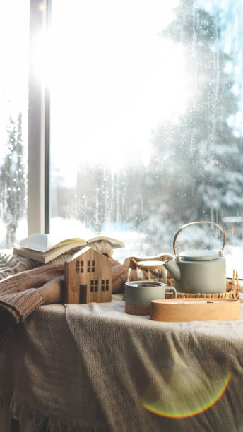 istock Cozy winter photo, stack of sweaters, book, tea and candle 1935414036