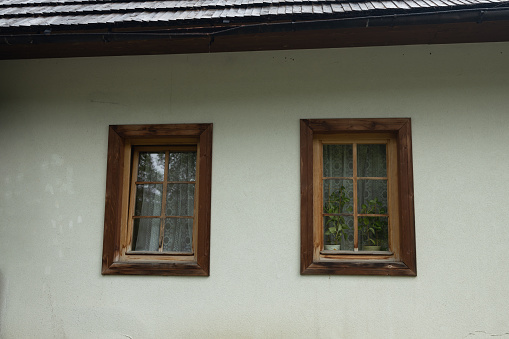 Two old windows with wooden frames, a fragment of the facade of an old building in Tatra Mountains, Poland.