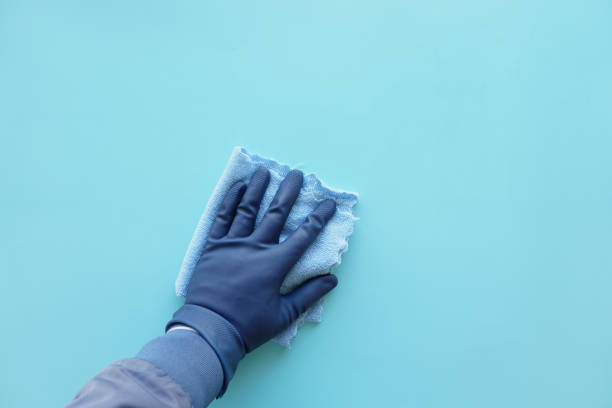 istock hand in blue rubber gloves cleaning table with cloth 1935434973