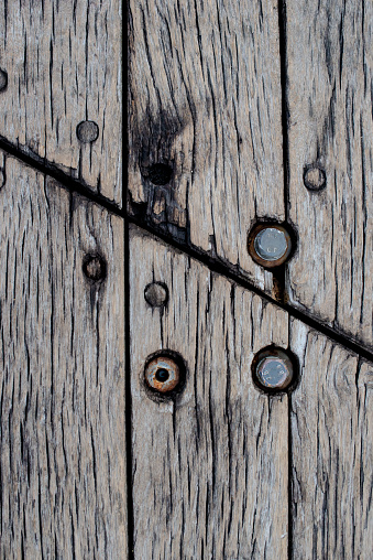 A detailed close-up photograph showcasing the weathered texture and intricate grain pattern of a vintage wooden plank board