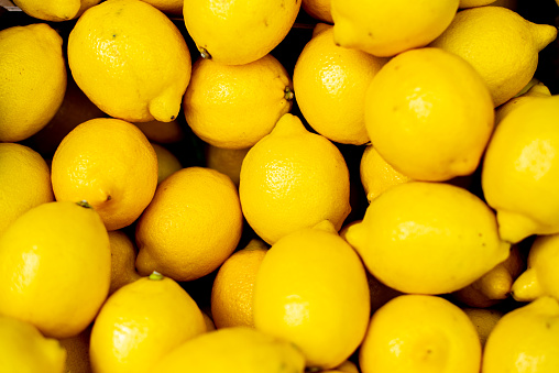 A vibrant arrangement of fresh yellow lemons neatly arranged in a row, showcasing their bright color and natural beauty